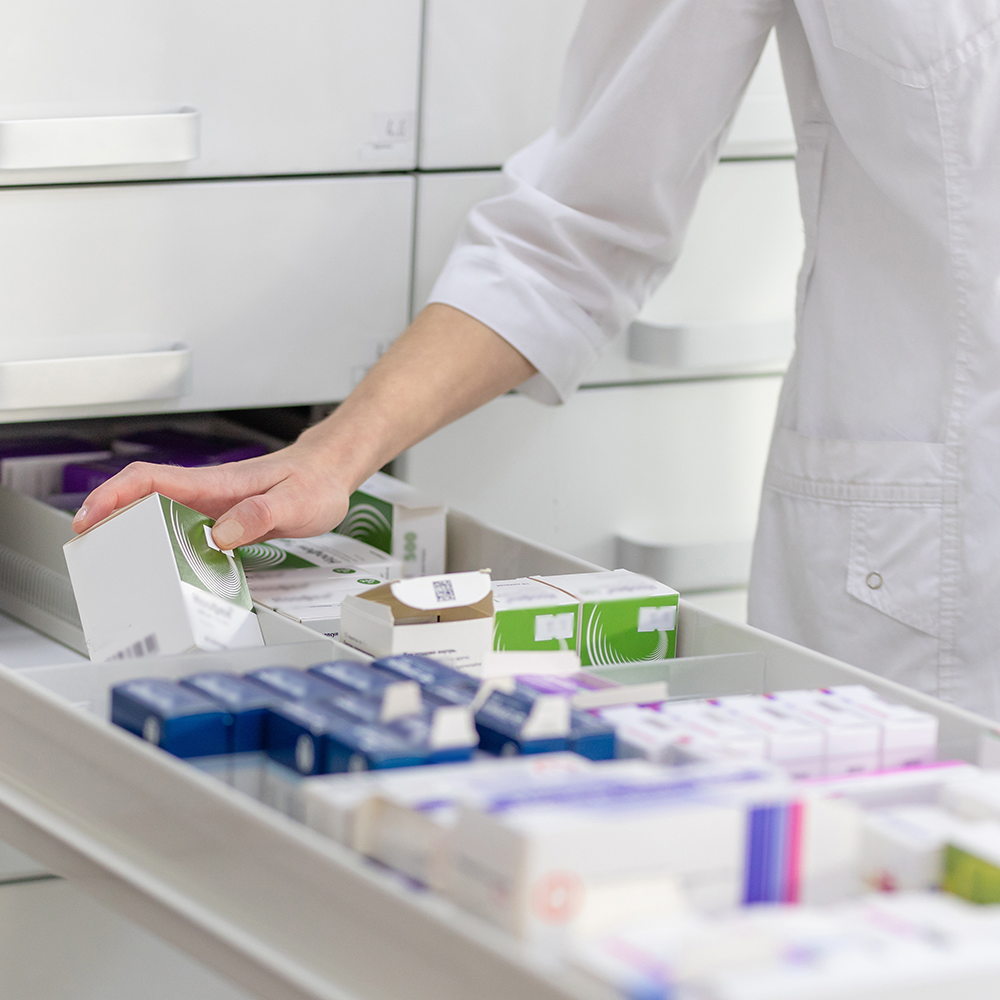 A pharmacist opening a drawer with medications